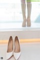 A pair of white wedding shoes sitting on top of a window sill.